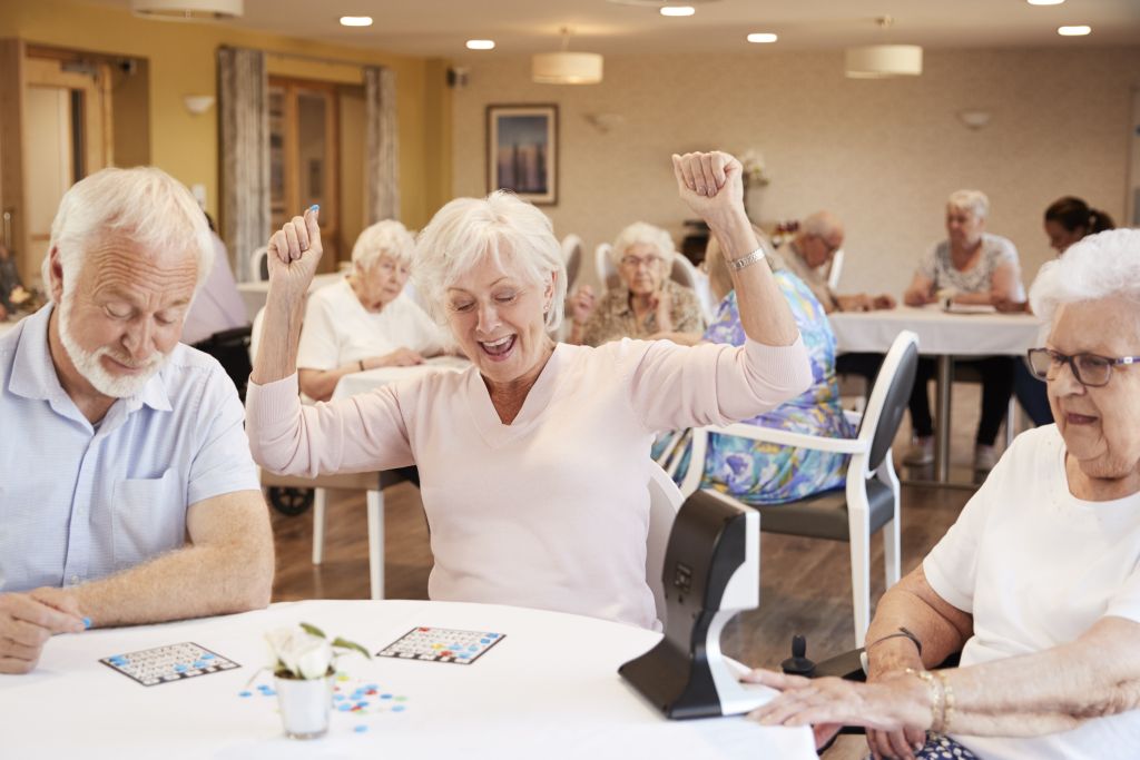 Senior Woman Winning Game Of Bingo In Retirement Home woman_playing_bingo