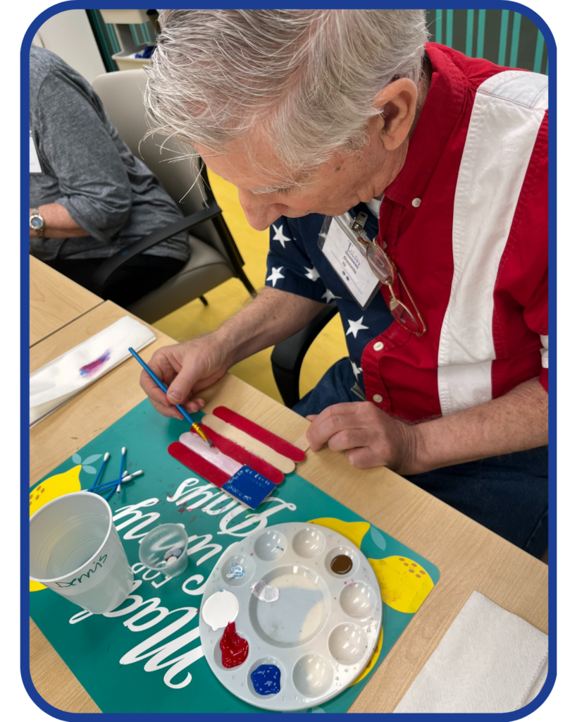 Austin Texas Veterans find care and connection at Town Square Adult Day Center. Senior paints an American Flag craft.