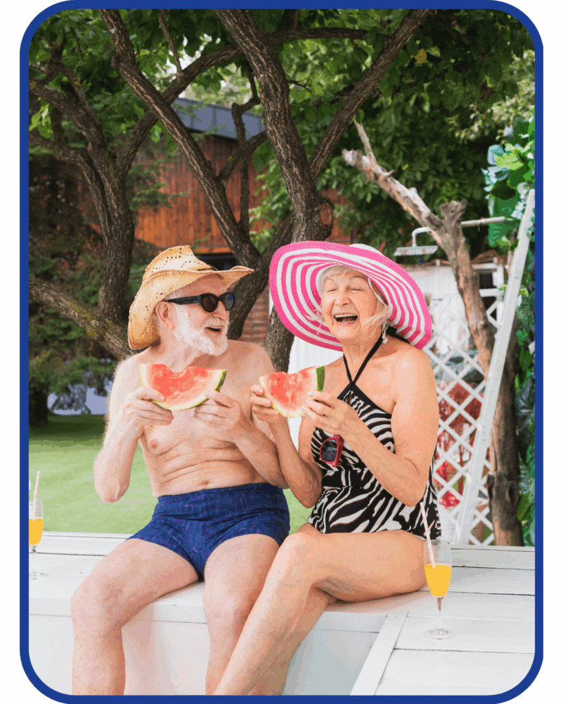 Older man and woman in sunhats laughing and eating watermelon slices outdoors—illustrating fun, hydrating summer snacks for Austin seniors.