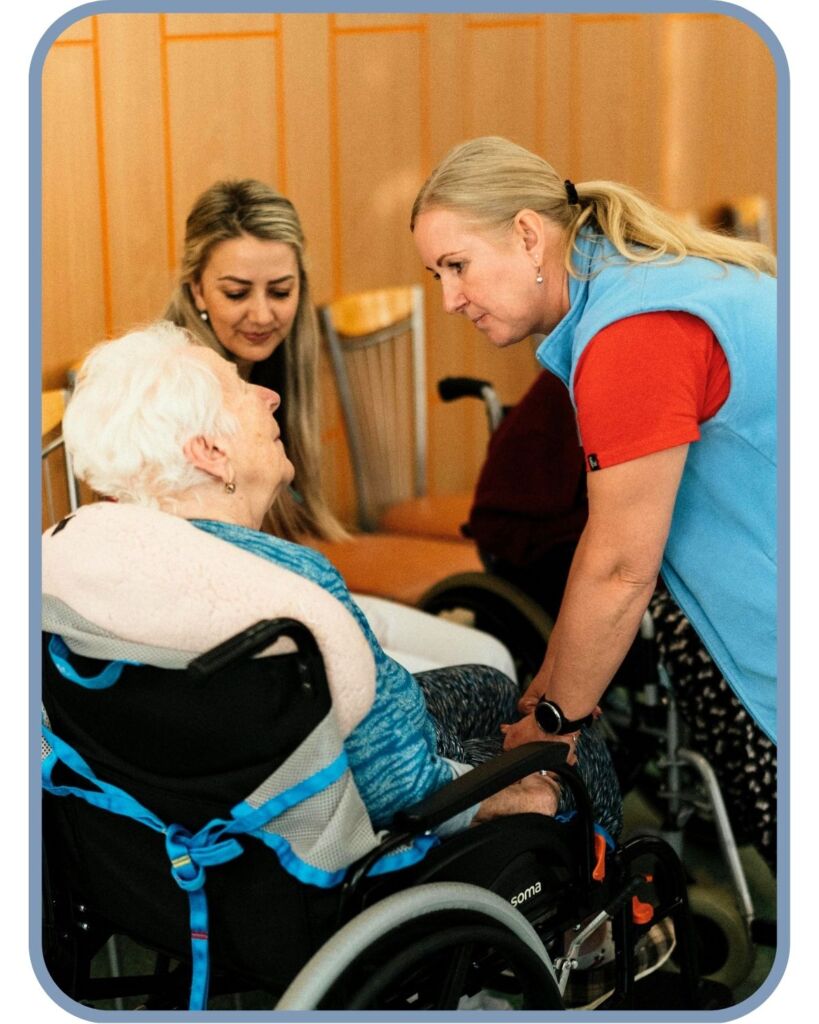 Caregiver offering one-on-one support to a senior in a wheelchair at Town Square NW Austin, highlighting adult day care support for seniors recovering after illness or injury and relief for overwhelmed