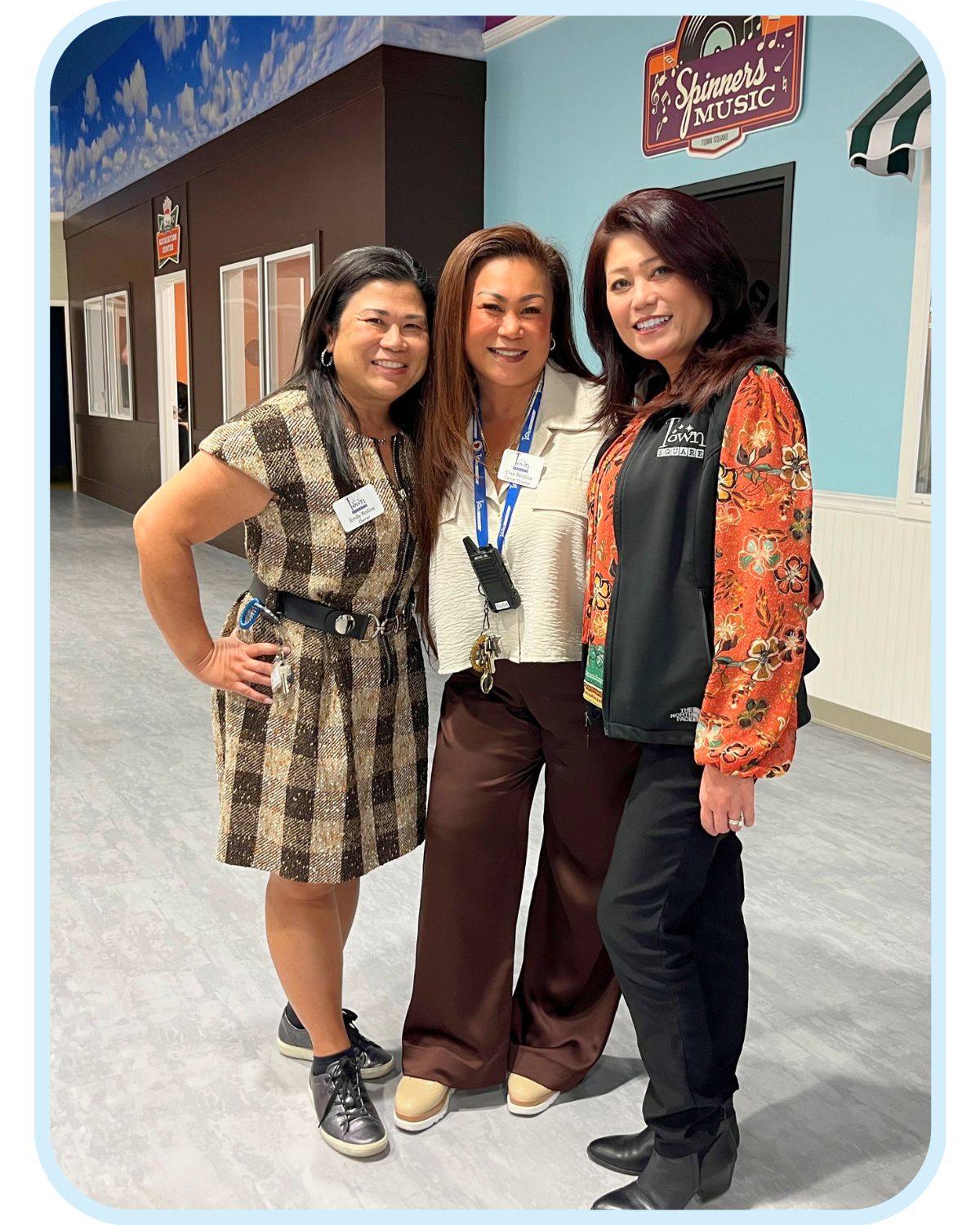 Three staff members smiling together inside Town Square NW Austin adult day care, representing supportive dementia care and a welcoming environment for caregivers and seniors.