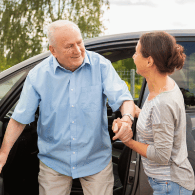 TS - Driving Transitions senior man being helped out of a car by a female caregiver